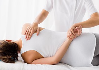 치료용 침대에서 허리 도수 치료를 받는 환자