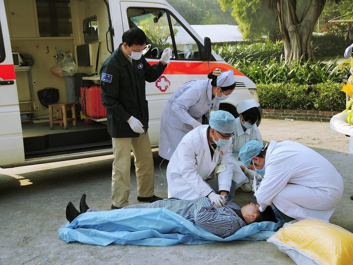 응급처치 현장 — 구급차 옆에서 심폐소생술을 시행하는 모습