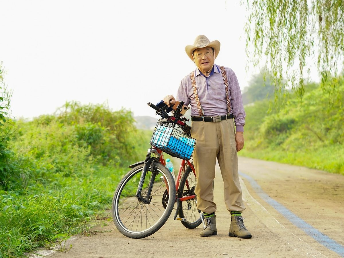 골다공증 관리 — 자전거를 세워 두고 산책로에 선 모습